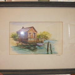 SIGNED WATERCOLOR FRAMED AND MATTED UNDER GLASS CABIN ON WATER 17 1/2″ X 13 1/2″