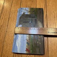 A rustic outhouse painting signed by Pat Flowers on a wood slice 12×7-1/2”
