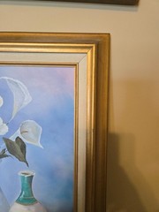 vintage framed artwork depicts white calla lilies in vases