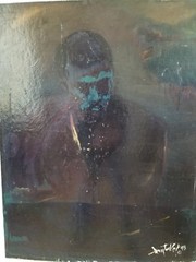 An expessive, dark painting of a tribal man, signed Tucker, 1993
